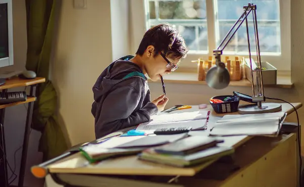 A boy  doing his homework on the table